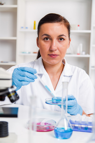 Young Female Scientist Analyzing Sample In Laboratory. Laboratoriumassistent die een monster analyseert. - Foto, afbeelding