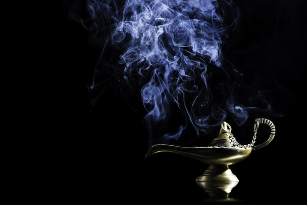 Magic lamp from the story of Aladdin with Genie appearing in blue smoke concept for wishing, luck and magic - Foto, afbeelding