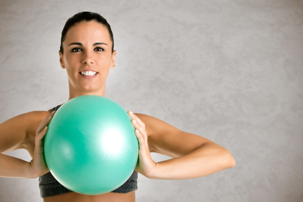Fit Woman Standing Holding a Pilates Ball - Photo, image