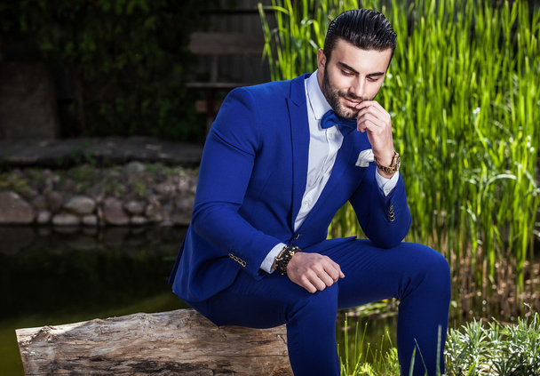 Elegant handsome man in classical blue costume pose outdoor - Fotó, kép