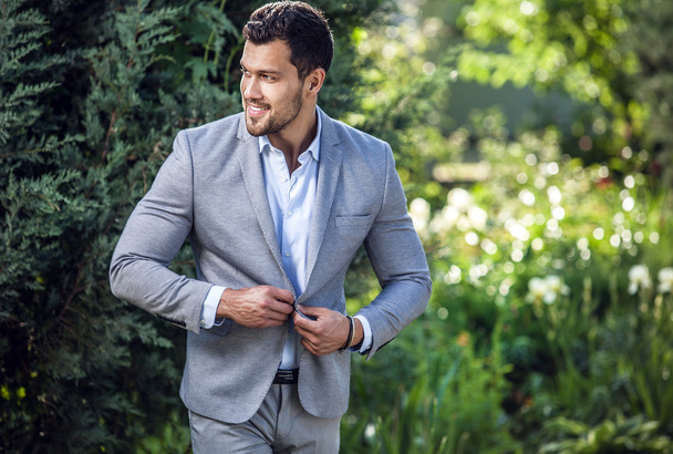 Elegant handsome man in classical jacket poses outdoor - Фото, изображение