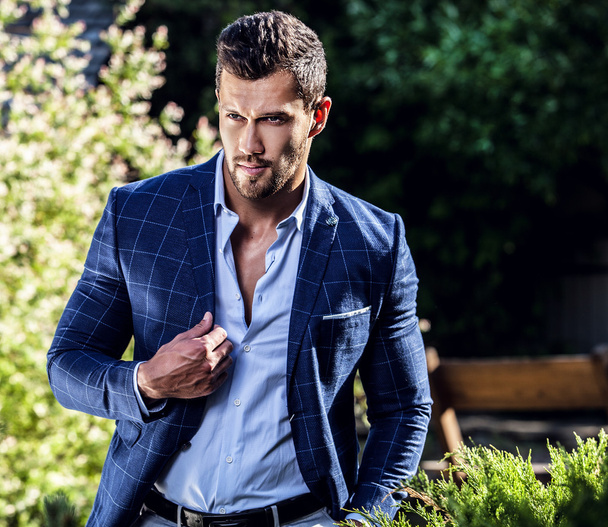 Elegant handsome man in classical jacket poses outdoor - Fotó, kép