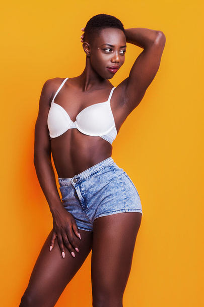 Beautiful african girl wearing jeans shorts and bra while posing - Foto, immagini