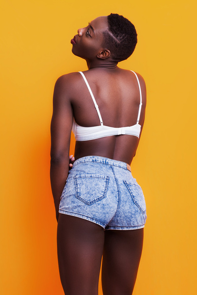 Pretty african girl back portrait wearing jeans shorts and bra - Photo, Image