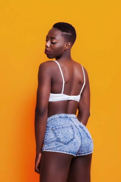 Dziewczyna dość Afryki pleców portret na sobie dżinsy szorty - Zdjęcie, obraz