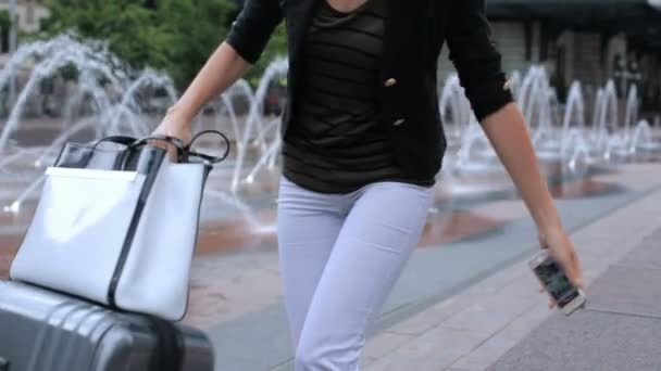 žena s kufrem na náměstí s fontánami jet  - Záběry, video