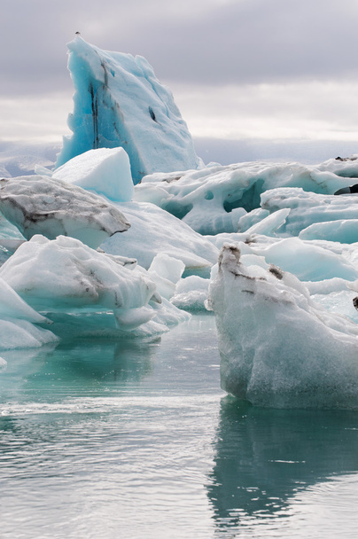 IJsland, Europa: drijvende ijsbergen in de Jokulsarlon gletsjerlagune, een groot gletsjermeer in Zuidoost-IJsland, aan de rand van het Vatnajokull National Park, ontwikkeld nadat de gletsjer is teruggetrokken van de rand van de Atlantische Oceaan - Foto, afbeelding