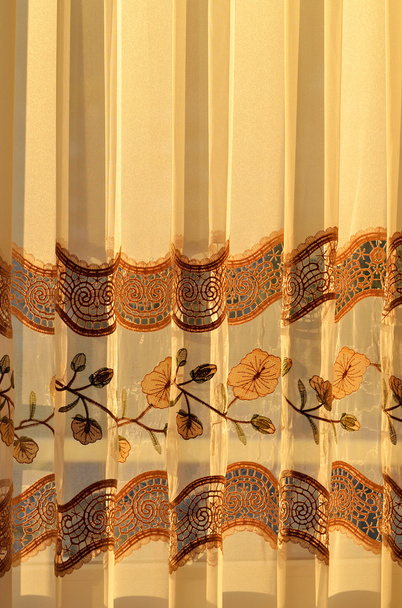 Luxo drapeado cortina decorativa dourada dentro de casa ao pôr do sol
 - Foto, Imagem