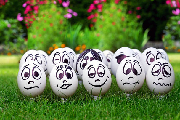 witte eieren en vele grappige gezichten, tuin partij - Foto, afbeelding