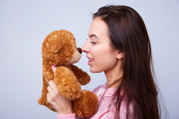 brunette playing with teddy bear - Фото, зображення