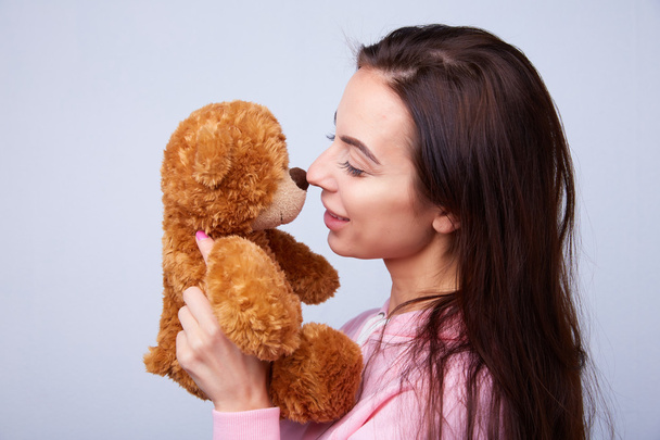 brunette playing with teddy bear - Foto, afbeelding