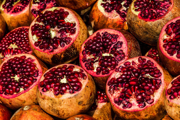 Juicy pomegranates cut fruits on market, background - Foto, imagen