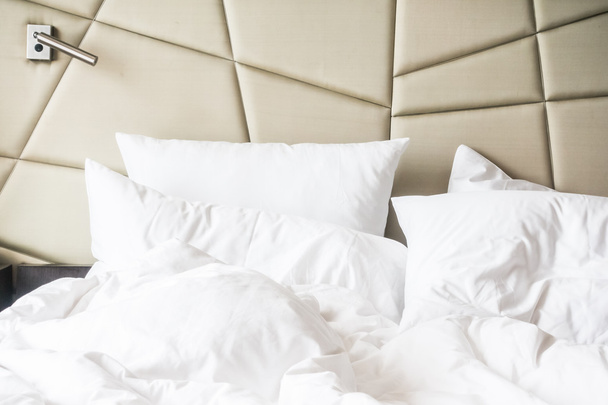 白の乱雑な枕でしわくちゃのベッド  - 写真・画像