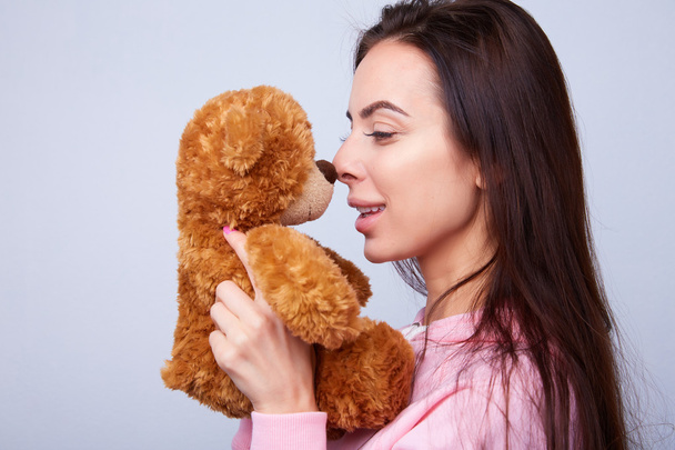 brunette playing with teddy bear - Фото, зображення