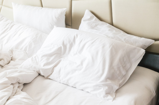 Rumpeliges Bett mit weißem, unordentlichem Kissen  - Foto, Bild