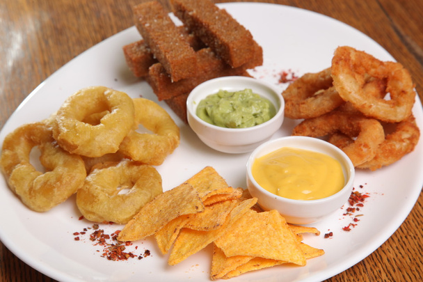 set of appetizers to beer and sauces on plate - Foto, afbeelding