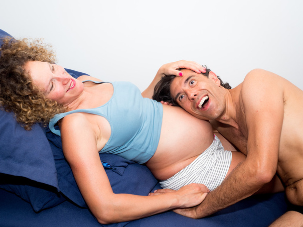 Vader luisteren gelukkig haar zwangere vrouw buik verwacht zijn ne - Foto, afbeelding