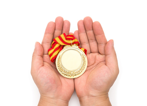 άνθρωπος που κρατά ένα χρυσό μετάλλιο σε λευκό φόντο - Φωτογραφία, εικόνα
