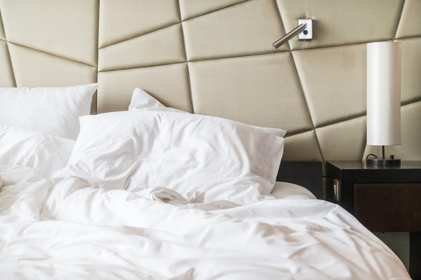 Смятая кровать с белой грязной подушкой
  - Фото, изображение