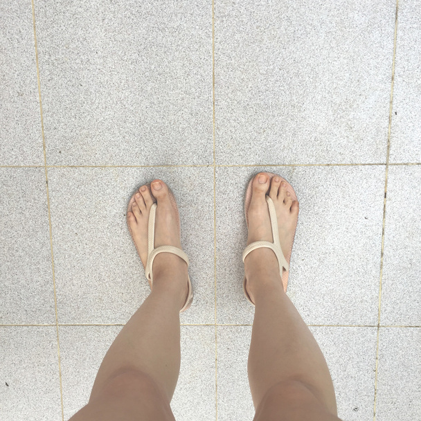 Woman legs and feet stand on the floor - Fotó, kép