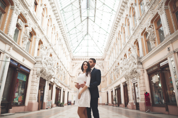 Beautiful wedding couple, bride, groom kissing and hugging against the background of old building - Φωτογραφία, εικόνα