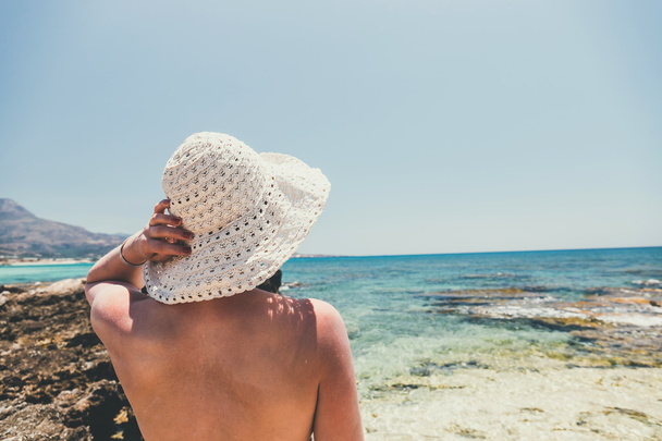 mujer con sombrero de paja protege del sol en la playa
 - Foto, imagen