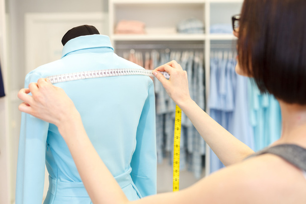 Talented fashion designer taking measurements of cloth - 写真・画像