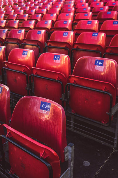Red seats at an outdoor stadium - Foto, Bild