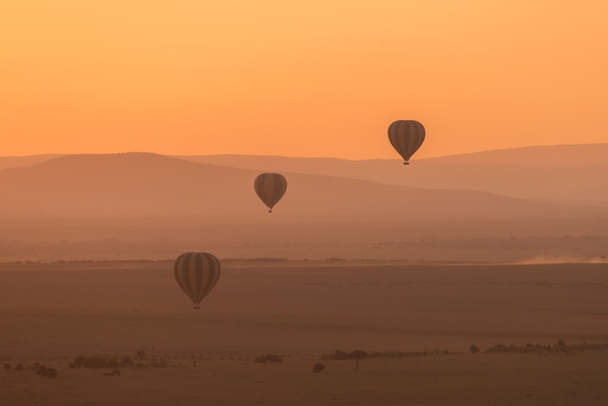 drei gestreifte Luftballons fliegen über lila Hügel - Foto, Bild