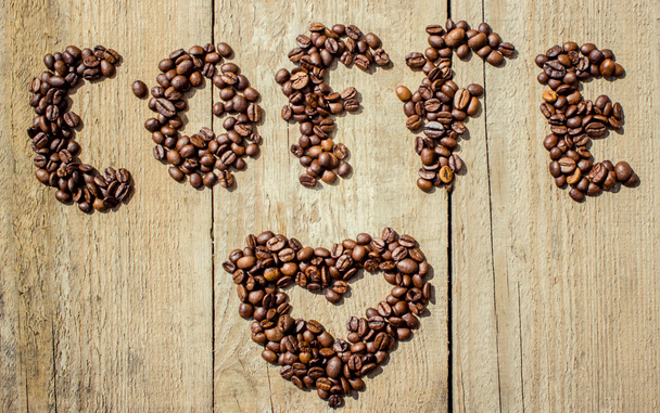 čerstvá kávová zrna na dřevě a plátěný pytel, připravena vařit lahodné kávy - Fotografie, Obrázek