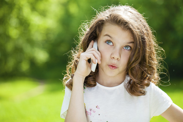 Portrait of a beautiful young little girl calling by phone - Fotografie, Obrázek