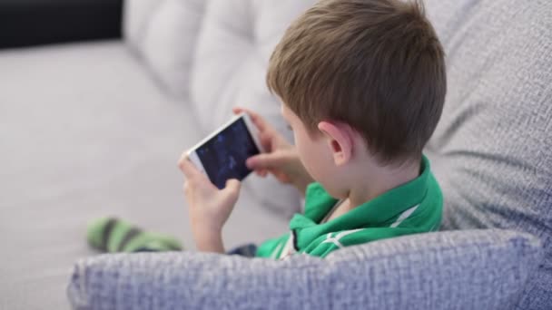 Little boy playing on a smartphone - Materiał filmowy, wideo