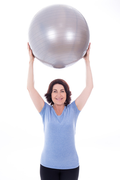 happy sporty mature woman with fitness ball isolated on white - Fotó, kép