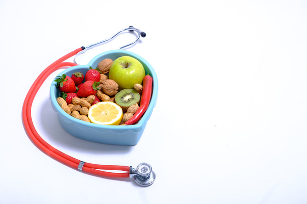 Heart shaped dish with vegetables and stethoscope isolated on white background - Foto, Bild