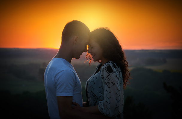 young couple at sunset on sky background, love concept, romantic people - Photo, Image