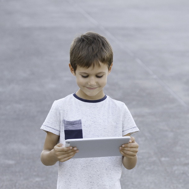 Χαμογελαστή αγόρι με Tablet PC. παιδική ηλικία, εκπαίδευση, μάθηση, τεχνολογία, αναψυχή έννοια - Φωτογραφία, εικόνα