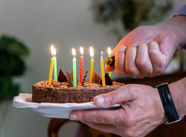 Kerzen auf Geburtstagstorte entzünden - Foto, Bild