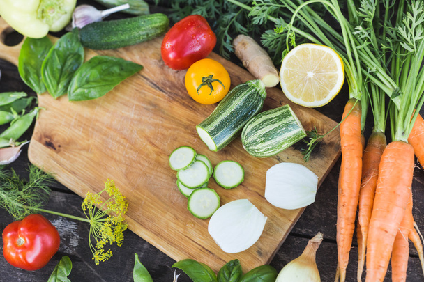 Closeup čerstvých Farmářský trh místně pěstované organické nakrájenou zeleninu na prkně. Dřevěné pozadí. - Fotografie, Obrázek