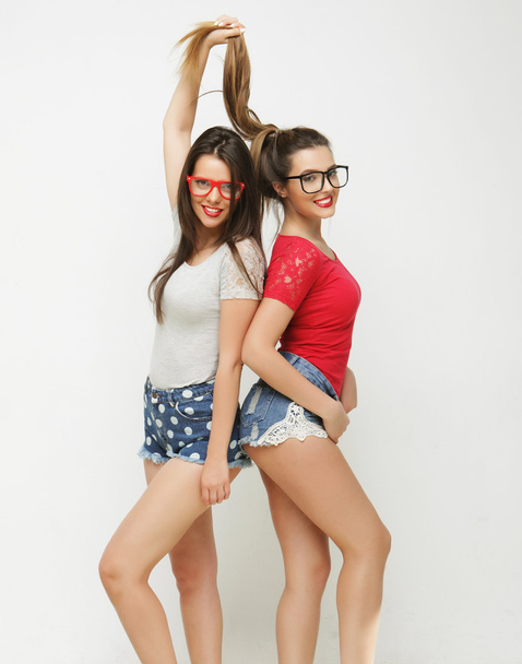 Two young girl friends standing together and having fun. - Foto, afbeelding