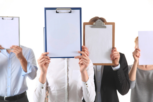 Team of businesspeople holding a folders near face isolated on white background - Zdjęcie, obraz