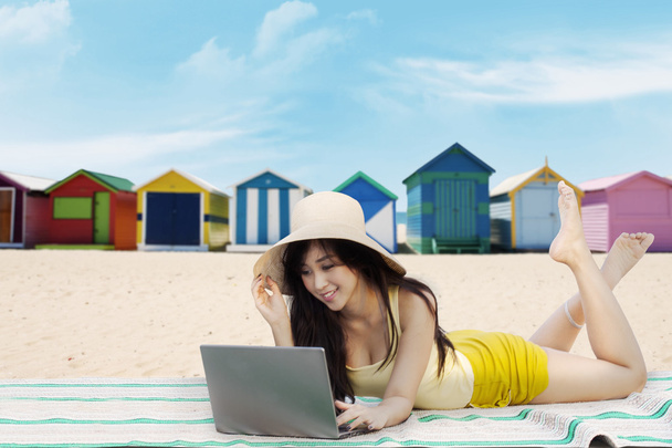 Жіноча модель використовує ноутбук на березі моря
 - Фото, зображення