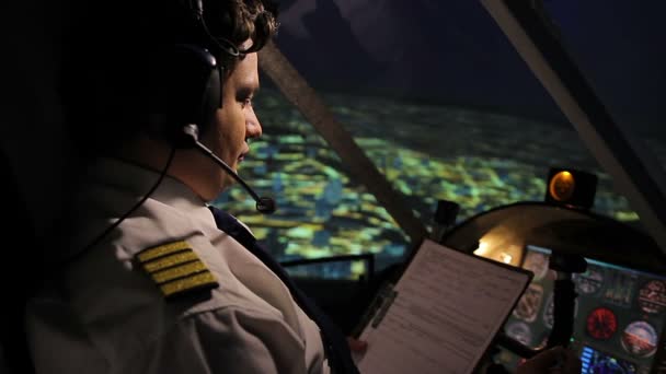 Pilot reading and filling out flight form, navigating plane in autopilot mode - Záběry, video