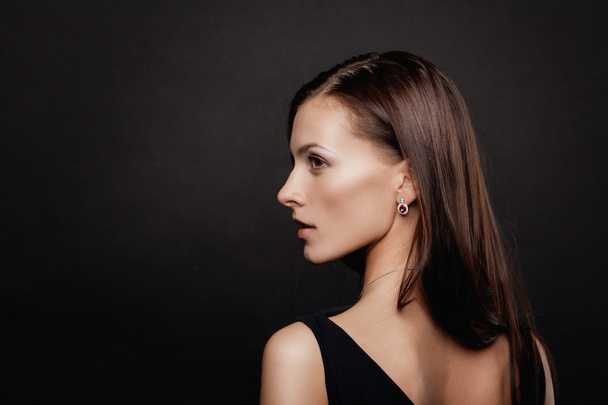 Brunette woman face portrait over dark background - Valokuva, kuva