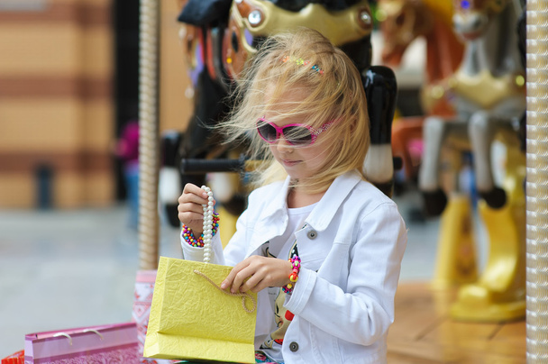 Lapsi ostoskassien kanssa tarkistamassa ostoksia
 - Valokuva, kuva