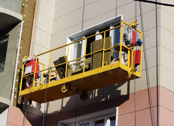 Gelbe Wiege ohne Arbeiter an einem neu errichteten Hochhaus - Foto, Bild