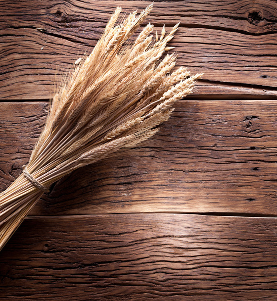 Ears of wheat on old wooden table. - Фото, зображення