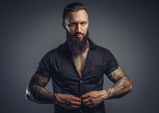 Hombre tatuado quitándose la camisa
 - Foto, Imagen