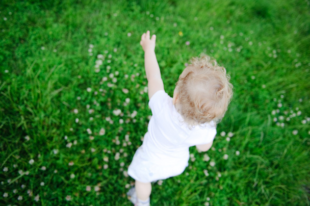 χαριτωμένο παιδί που παίζει στο πράσινο γρασίδι - Φωτογραφία, εικόνα