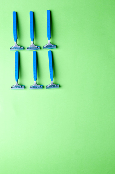 The image of blue razor blades ona a green bakground - Photo, Image