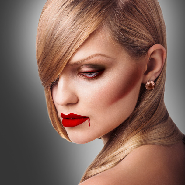 Молодая женщина-вампир с красной помадой
 - Фото, изображение